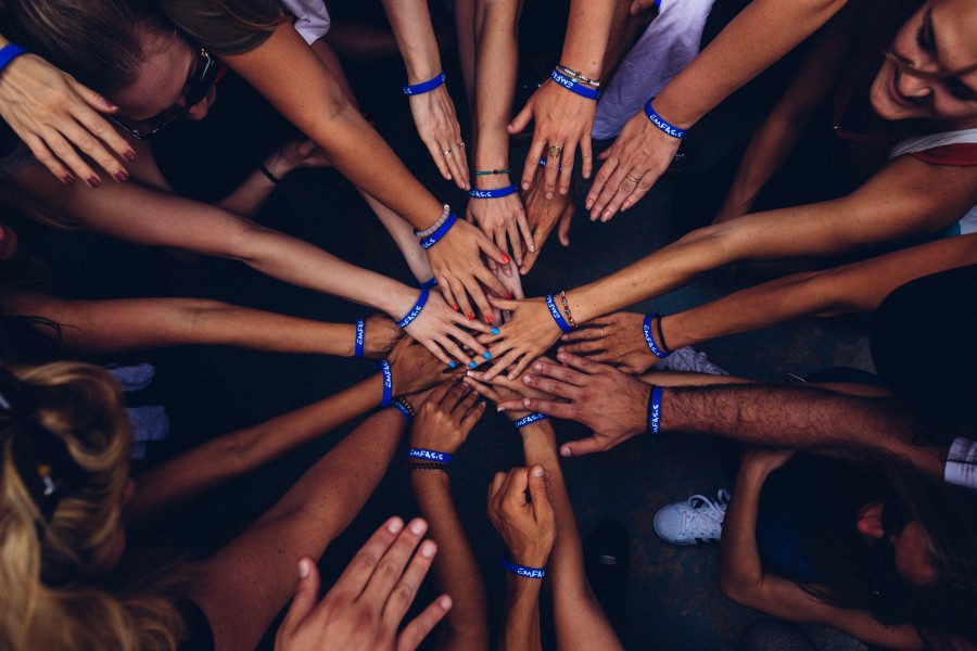 Image of Team hand-stack with blue wristbands 